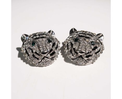 Pair of post back stud earrings designed in the shape of stylized tiger heads. Each earring is encrusted with numerous clear 