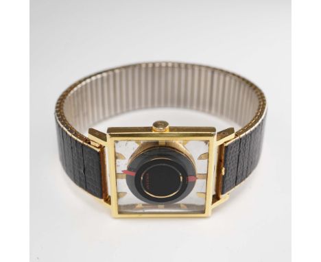 A vintage wristwatch featuring a striking mystery dial with a black and gold concentric layout and red floating hands. Housed