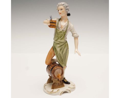 Hand painted figure depicting a brewer holding a stein of beer while leaning against the keg. Colored in hues of green, brown