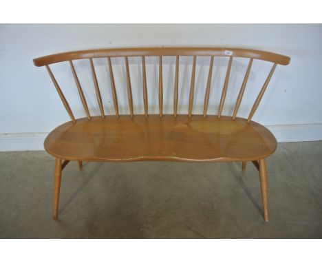 A Ercol Elm and Beechwood bench with a shaped seat and stick back - in sound condition and normal wear and tear for its age -