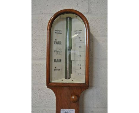 A 19th Century oak stick barometer with an ivory dial -  signed Negretti and Zambra over a thermometer - in good condition an