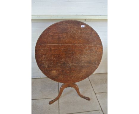 A Georgian oak tripod table on three outswept legs and an 86cm diameter top which needs repolishing