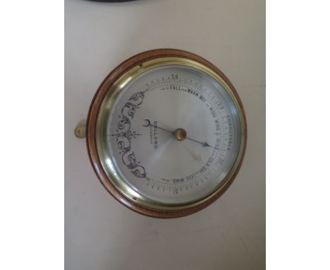 An oak cased aneroid bulkhead barometer by Dolland of London - 17cm diameter