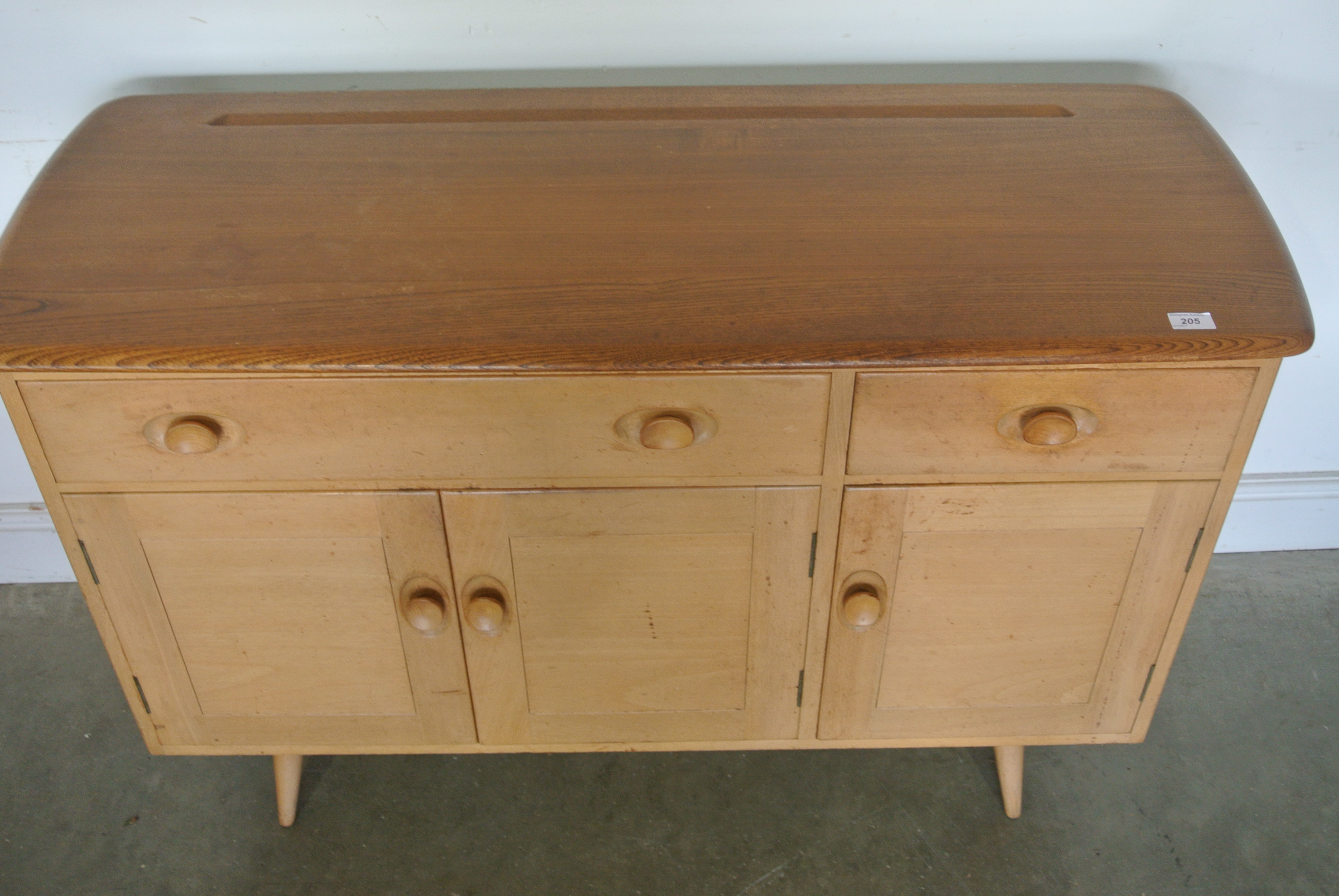 An Ercol sideboard with two drawers above three cupboard doors Height