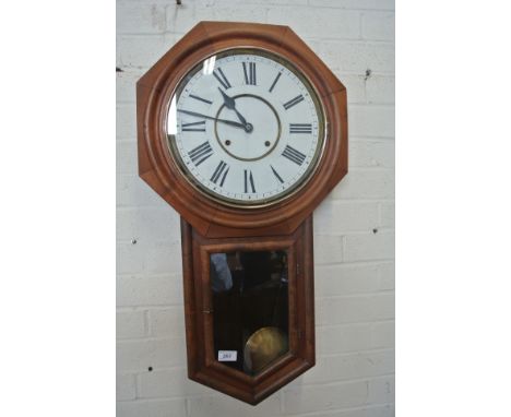 An American eight day wall clock drop-case showing pendulum, Roman numerals to white enamel dial