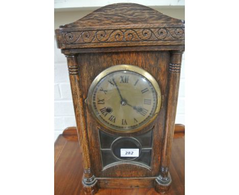 A striking mantle clock in an oak case - in working order - 38cm high