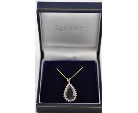 A 9ct gold pear shaped sapphire pendant with diamond cluster surround with 9ct gold chain.