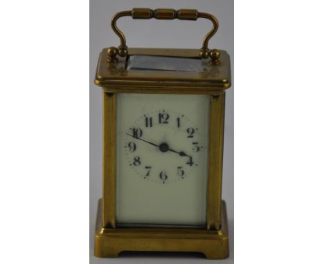 An early 20th century carriage timepiece, the corniche case with bevelled plates and a cream enamel dial set out in Roman num
