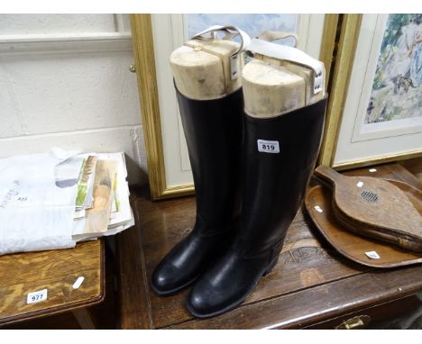 A pair of vintage leather riding boots together with a wooden shoe trees