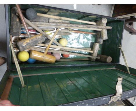 A vintage metal box containing croquet items
