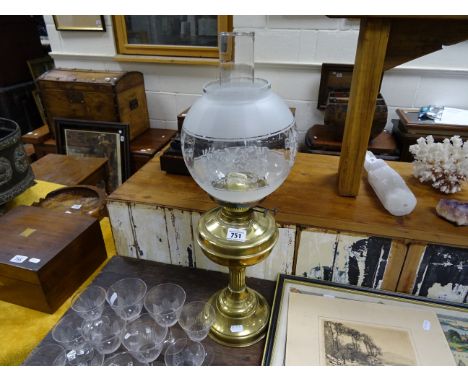 A vintage brass oil lamp with etched shade