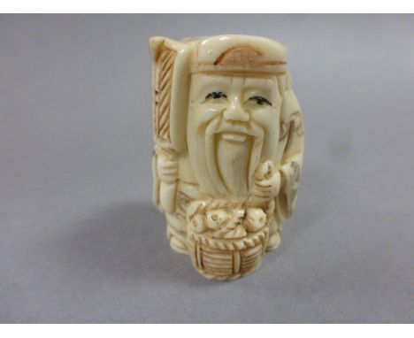 Signed oxbone netsuke of a man with fan and basket