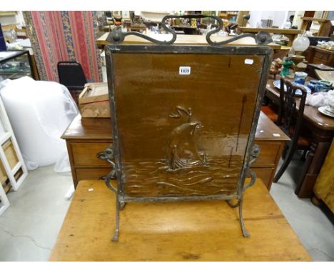 An Arts and Crafts copper firescreen; in the Newlyn style; embossed with a Galleon; raised on iron strap work supports