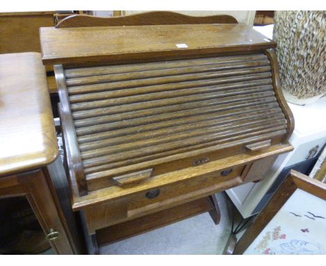 An early 20th century oak roll top desk; with drawer and shelf below