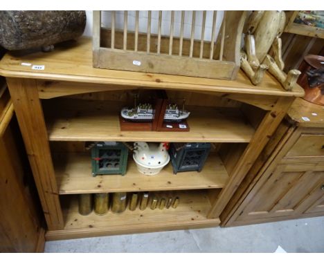 A pine three shelf open bookcase; raised on plain plinth base