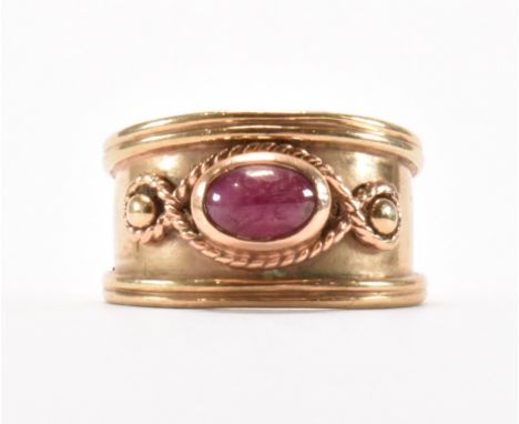 A hallmarked 9ct gold and star ruby ring. The ring having an oval star ruby cabochon with rope twist detailing. Hallmarked Sh