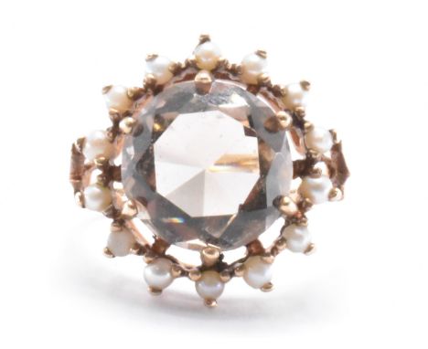 A vintage gold smokey quartz and seed pearl dress ring. The ring set with a round cut smokey quartz with a halo of seed pearl