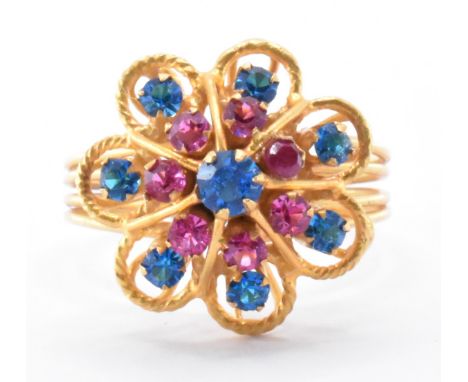 An 18ct gold and gemstone cluster harem ring. The ring set with synthetic ruby and blue stones to cluster setting with filigr