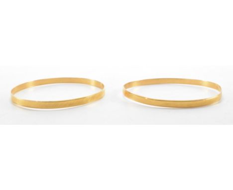 A pair of gold bangle bracelets. The bangles having incised decoration to the sides. Both marked 750, tests indicate 18ct gol