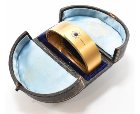 A 19th Century Victorian 15ct gold pearl and sapphire bangle. The bangle set with a central round cut sapphire framed by a ha