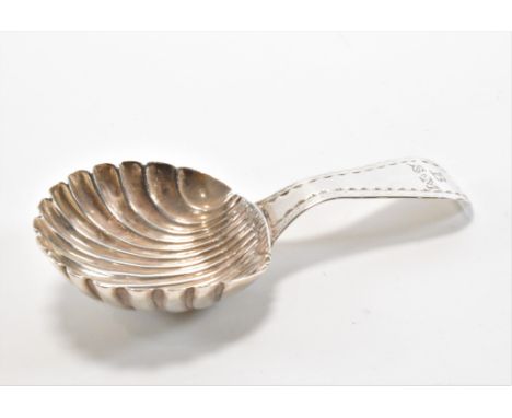 A late 18th Century George III silver hallmarked tea caddy spoon. The spoon having a scallop shaped bowl with a rounded handl