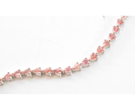 A padparadscha line tennis bracelet. The bracelet set with 38 claw mounted pear cut padparadscha sapphires. The body of the b