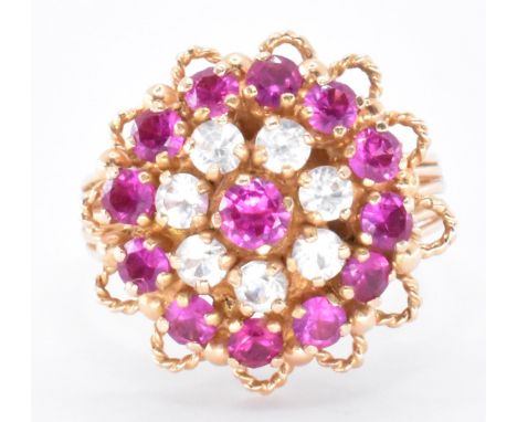 An 18ct gold and gemstone cluster harem ring. The ring set with synthetic ruby and white stones to cluster setting with filig