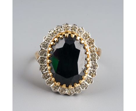 A 9ct yellow gold sapphire and diamond cluster ring, set with a large oval mixed-cut sapphire within a border of small diamon