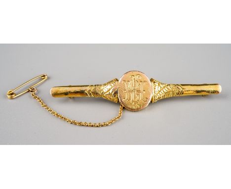 A 9ct yellow gold bar brooch, probably made from a ring, monogrammed oval centre, approx 6.5cm long, total gross weight appro
