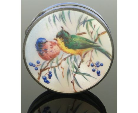 A circular silver and coloured enamel pillbox,
the hinged lid having a painted enamel design of 2 birds on a branch, by Carri