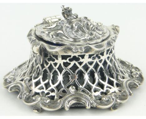 An ornate early Victorian cast silver inkwell,
with pierced concave fretwork surround and original Bristol Blue glass liner, 