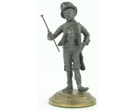 A spelter cigar lighter in the form of a man holding a walking cane,
on circular brass plinth, overall height 8".