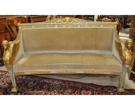 An 18/19th century French Empire carved, painted and gilded sofa,
having allover carved and gilded decoration, with seraphim 