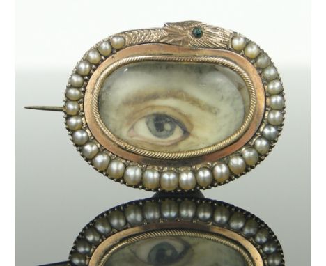 Unmarked gold brooch,
with inset painted eye in pearl serpent design surround, width 32mm.
