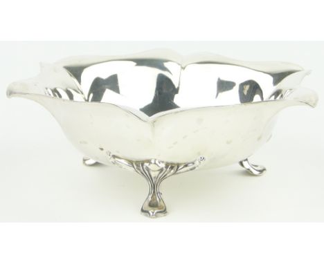 An Edwardian silver table centre bowl,
with scalloped surround, raised on stylised feet, makers marks H A, Sheffield 1903, 8.