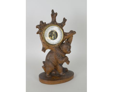 A Black Forest Barometer in the form of a bear carrying the circular dial, 13in H