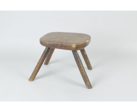 An antique elm rustic Milking Stool on four stick legs, stamped GS on underside of seat, 8 1/2in H