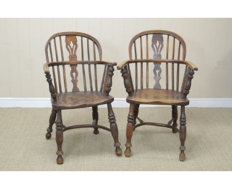 A pair of 19th century Windsor Armchairs with pierced splats and stick backs, solid seats on turned legs united by crinoline 