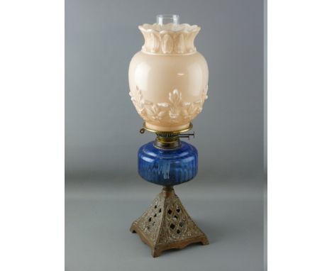 A VICTORIAN OIL LAMP with iron base, blue glass reservoir and milk glass shade