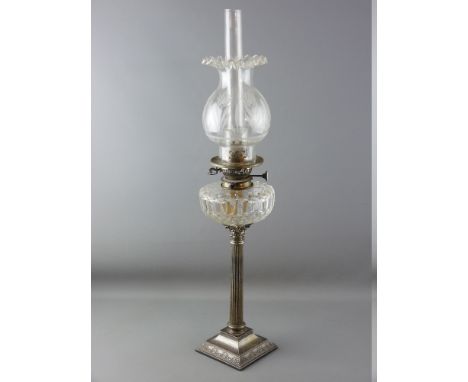 A VICTORIAN OIL LAMP with metal Corinthian column having a clear glass reservoir and clear etched glass shade