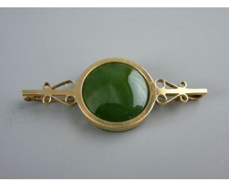 A NINE CARAT GOLD BROOCH with circular jade or green agate tablet, 6 grms gross