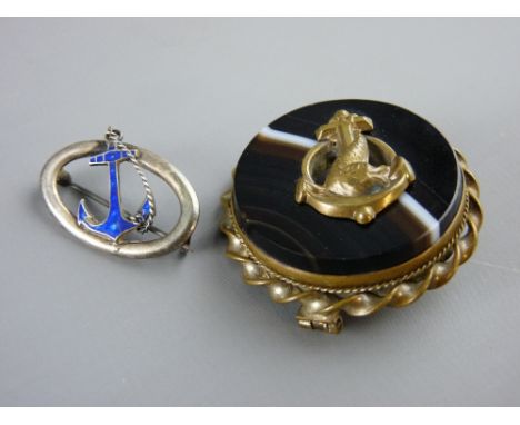 A CIRCULAR YELLOW METAL ROPE TWIST FRAMED AGATE BROOCH with dolphin to the centre and a silver and enamel anchor brooch