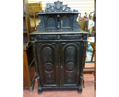 A 19th CENTURY EUROPEAN EBONIZED SIDE CABINET, the top shelf sectioned with carved detail repeated to a single frieze drawer 