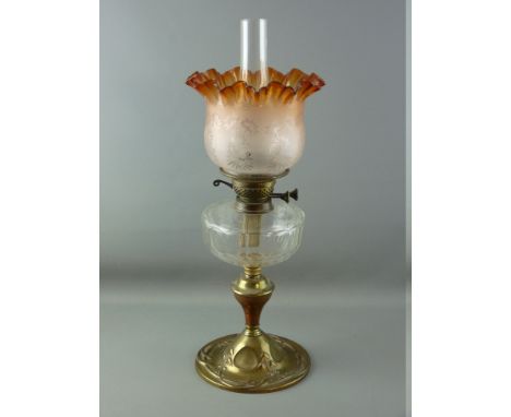 A VICTORIAN OIL LAMP with brass column, clear glass reservoir and amber coloured etched glass shade