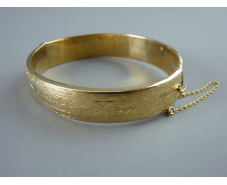 A NINE CARAT GOLD HALF BRIGHT CUT HOLLOW BANGLE, 21.5 grms gross