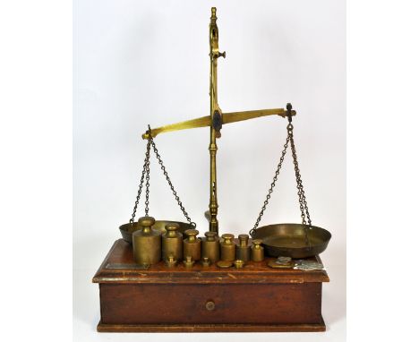 A wood and brass balance scale and weights.