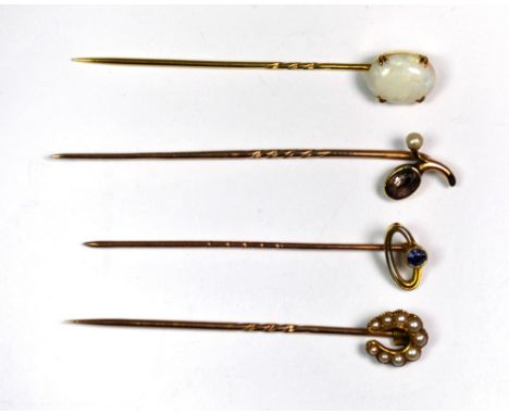 A 9ct gold opal set stick pin, together with a 15ct gold sapphire set stick pin and two further yellow metal stick pins.