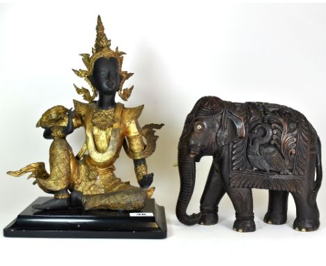 A Thai gilt bronze seated figure of a dancer (H. 38cm) and a decorative carved hardwood elephant (H. 23cm).