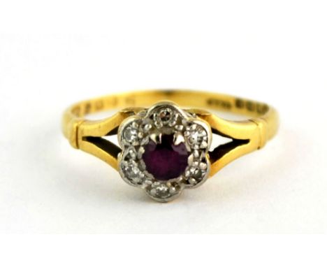 An 18ct yellow gold ring set with a ruby surrounded by diamonds (I.5).