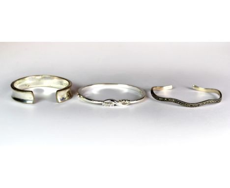 Two silver bangles and one white metal bangle.